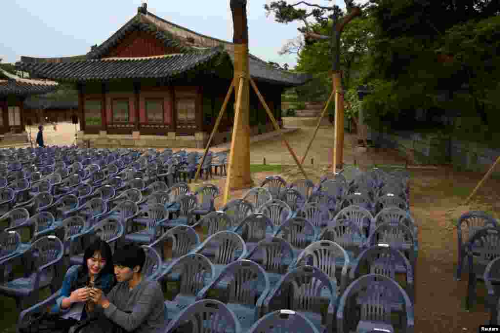 A couple uses a smartphone as they wait for the start of a shadow play performance at Changgyeonggung Palace in Seoul.