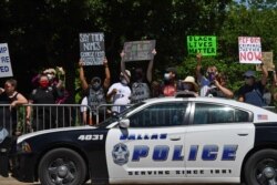 Protesters hold placards near Gateway Church Dallas Campus as U.S. President Donald Trump arrives for a roundtable with faith leaders and small business owners in Dallas, Texas, June 11, 2020.