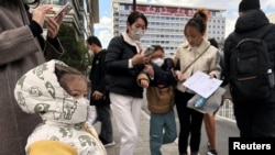 People and children leave a children's hospital in Beijing