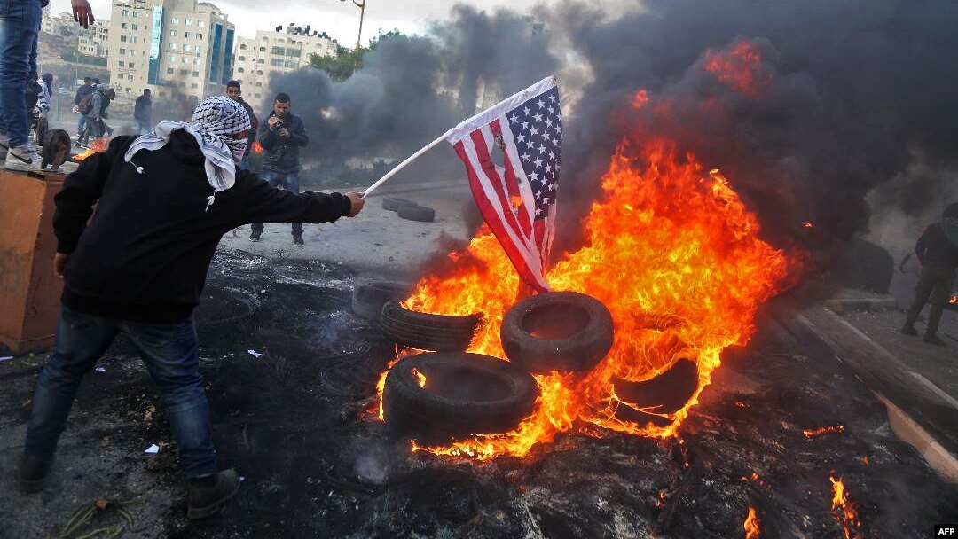 Demonstran Palestina membakar bendera AS dalam aksi protes terhadap keputusan Presiden Donald Trump untuk mengakui Yerusalem sebagai ibu kota Israel, di Beit El, Tepi Barat Kamis (7/12). 