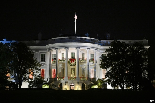 The White House is seen decorated with Christmas decorations during the unveiling of the holiday ice skating rink, on the South Lawn of the White House in Washington, DC, on November 29, 2023. (Photo by Mandel NGAN / AFP)