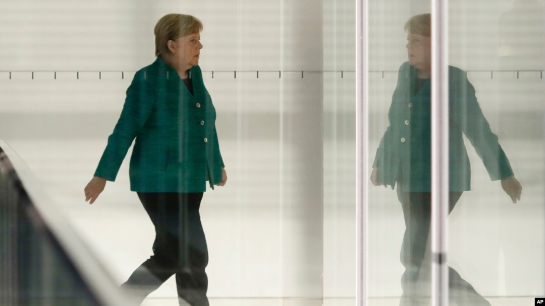 FILE - German Chancellor Angela Merkel walks through a corridor of the Reichstag building during a Christian Union parties faction meeting in Berlin, Sept. 25, 2018.