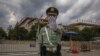 A Chinese People's Liberation Army (PLA) soldier wearing a protective face mask gestures to the photographer to stop taking photos in front of the Great Hall of the People, after the second plenary session of China's National People's Congress (NPC)…