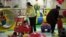 Parents play with their children at a kid's play area in a shopping mall in Beijing. Authors of a new study say the one-child policy has significant ramifications for Chinese society, January 10, 2013.