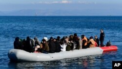 FILE - A Greek Coast Guard boat intercepts a dinghy with migrants near the Greek island of Lesbos, after it crossed the Aegean Sea from Turkey, March 1, 2020.