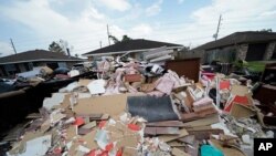 FILE - Debris piles up at curbside as residents gut their flooded homes in the aftermath of Hurricane Ida in LaPlace, La., Sept. 7, 2021.