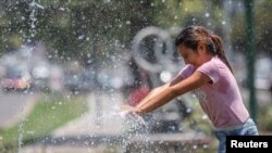 Una niña juega con agua mientras Argentina enfrenta una ola de calor histórica con temperaturas que superan los 40 grados centígrados (104 °F) y obliga a los residentes a buscar refugio a la sombra en Salta, Argentina, el 13 de enero de 2022.