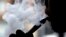 FILE - In this April 23, 2014 file photo, a man smokes an electronic cigarette in Chicago. 