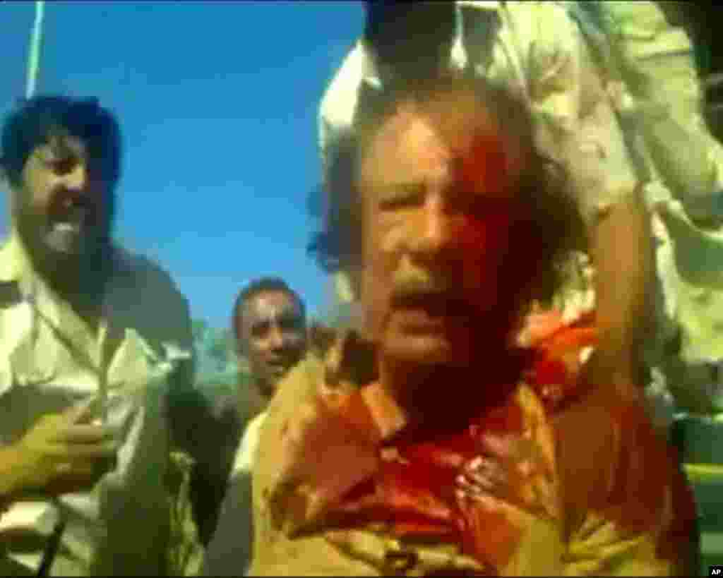 卡扎菲2011年10月20日受傷被捕的圖像在網上盛傳。 (美聯社)