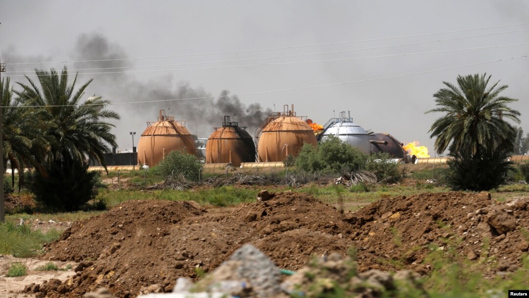 Asap membumbung dari tangki peyimpanan gas di pabrik pemrosesan gas untuk masak. Taji, utara Baghdad.