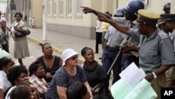 Zimbabwean police officers surround members of Women of Zimbabwe Arise (WOZA) during their demonstration against delays in the drafting of a new constitution outside parliament in Harare. (File AP Photo/Tsvangirayi Mukwazhi)