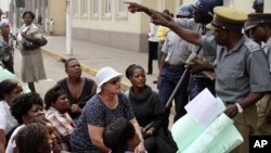 FILE: Zimbabwean police officers surround members of Women of Zimbabwe Arise (WOZA) during their demonstration against delays in the drafting of a new constitution outside the parliament in Harare, Tuesday, Sept. 11, 2012. (AP Photo/Tsvangirayi Mukwazhi)