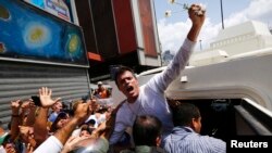 Leopoldo López es introducido dentro de un vehículo blindado de la Guardia Nacional luego de su captura el miércoles en Caracas.