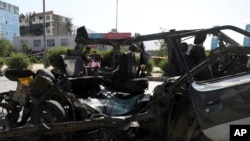 FILE - Afghan security personnel inspect the site of a bomb explosion that ripped through a minivan in Kabul, Afghanistan, Thursday, June 3, 2021.
