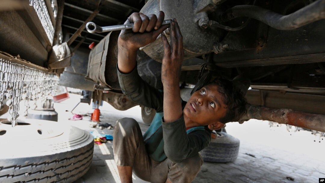 Seorang bocah berusia 10 tahun bekerja di sebuah bengkel di Lahore, Pakistan, untuk menghidupi keluarganya, 12 Juni 2021. (AP//K.M. Chaudary)
