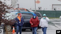Tyson Fresh Meats plant employees arrive at the plant, April 23, 2020, in Logansport, Ind.