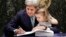 FILE - Then-U.S. Secretary of State John Kerry holds his granddaughter Isabel Dobbs-Higginson as he signs the Paris Agreement on climate change, April 22, 2016 at U.N. headquarters. 