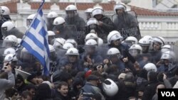 Policías antimotines contienen a los manifestantes frente al Parlamento.