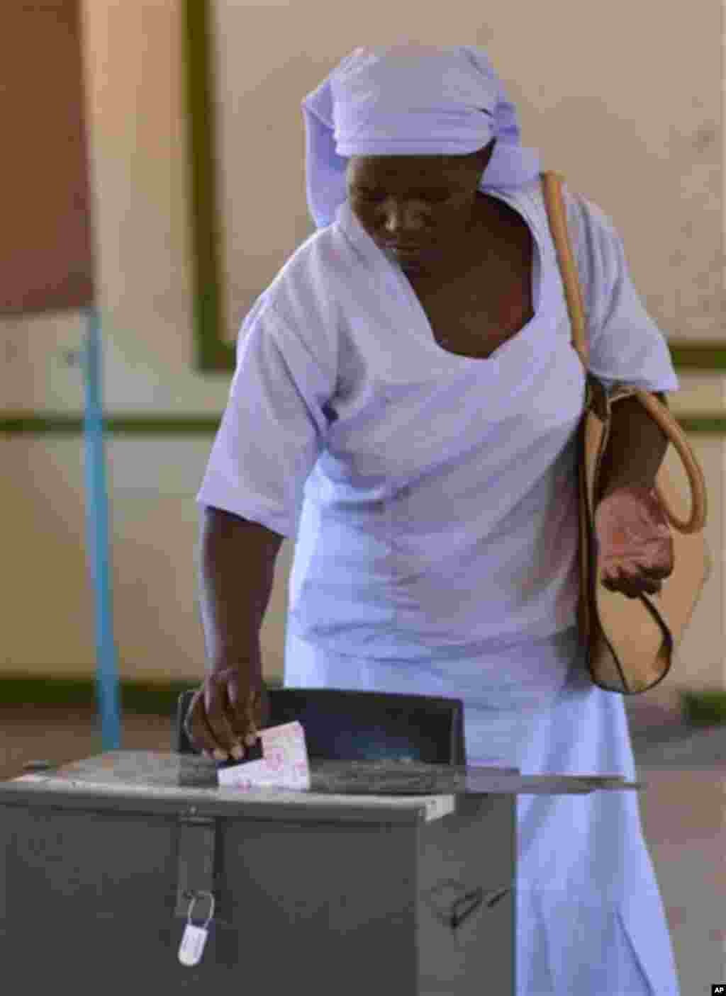 Un électeur dépose son bulletin de vote à un bureau de vote à Gaborone, au Botswana, le vendredi 24 octobre 2014. Les agents électoraux disent que le vote a commencé sans incident où des analystes estiment que le parti au pouvoir va gagner malgré le mécontentement croissant dans les zones urbaines. 