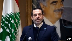 Former Lebanese Prime Minister Saad Hariri speaks during a press conference in front of a picture of his late father and former Lebanese Prime Minister Rafic Hariri, at his home in downtown Beirut, Lebanon, Jan. 24, 2022. 