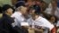 Cody Ross, derecha, de los Medias Rojas de Boston es detenido por su manager Bobby Valentine cuando protesta por haber sido declarado "out" en el juego contra los Yankees, en el Fenway Park de Boston, el miércoles 12 de septiembre.