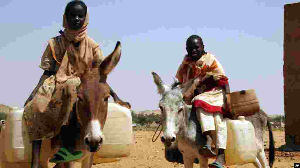 Deux jeunes filles quittent le camp de réfugiés de Fata Borno pour aller chercher de l'eau au Darfour, au Soudan le 14 octobre 2006.