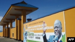 FILE - A banner of Tanzanian President John Magufuli adorns a wall in Merelani, Tanzania, April 11, 2018.