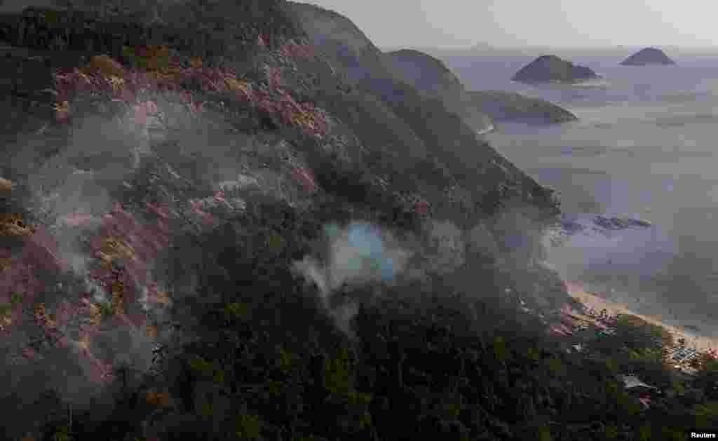 Vista desde un dron donde se observa el humo sobre la playa de Itaipú durante un incendio en el Morro das Andorinhas en Niteroi, estado de Río de Janeiro, Brasil. (REUTERS)