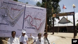 Cambodia Council of Ministers spokesman Phay Siphan, second right, points to maps during a press conference in front of the Wat Keo Sikha Kirisvara Buddhist pagoda near Cambodia's 11th century Hindu Preah Vihear temple in Preah Vihear province, February 4