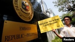 FILE - An activist from Amnesty International Thailand holds a banner during a rally to urge the Phillipines to stop 'War on Drugs' in front of Philippines's embassy in Bangkok, Thailand, April 25, 2017. 