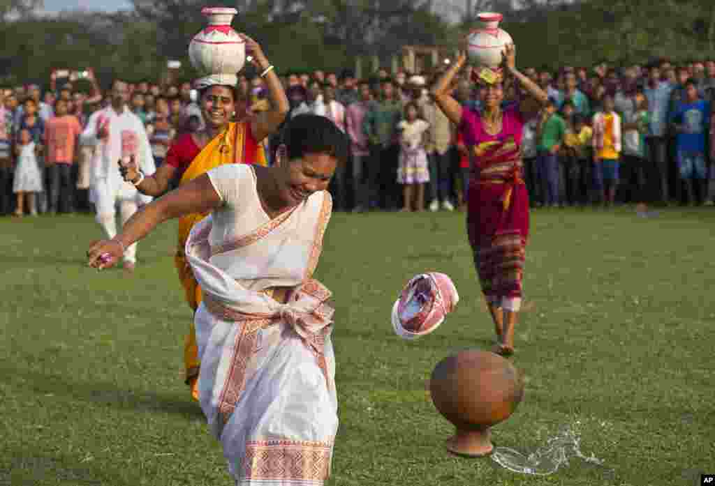 An Indian tribal woman reacts after an earthen pot filled with water falls off her head during a 100-meter sprint event with water pots on heads, in the Suwori Tribal festival in Boko.