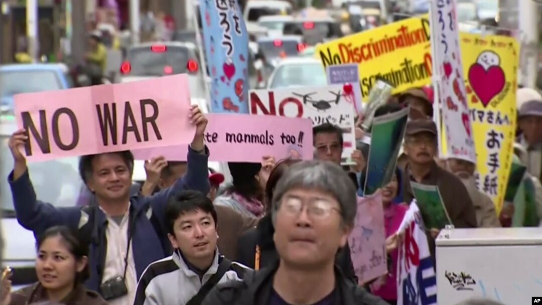 Manifestantes marchan en contra del traslado de la base de Okinawa a otro lugar de esa isla.