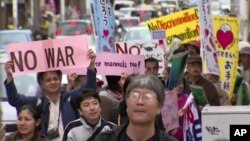 Manifestantes marchan en contra del traslado de la base de Okinawa a otro lugar de esa isla.