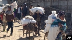 Families begin their journey home from the Estayesh food distribution site in Denkena Kebele, Meket Woreda, Ethiopia, Dec. 14, 2015. The government is appealing for $1.4 billion from the international community and donors to help feed more than 10 million people.