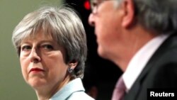 Britain's Prime Minister Theresa May and European Commission President Jean-Claude Juncker hold a news conference at the EC headquarters in Brussels, Dec. 8, 2017.