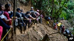 Fotografía de archivo donde se observa a un grupo de migrantes en su recorrido por el Tapón del Darién, entre Colombia y Panamá, el 15 de octubre de 2022.