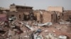 FILE - A man walks by a house hit in fighting in Khartoum, Sudan, an area torn by violence between the military and the notorious paramilitary Rapid Support Forces, April 25, 2023.