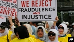 Para pendukung capres Prabowo Subianto menunjukkan poster-poster dalam unjuk rasa dekat gedung Mahkamah Konstitusi saat berlangsung sidang perdana sengketa pilpres 2019, di Jakarta, Jumat, 14 Juni 2019. (Foto: AP)