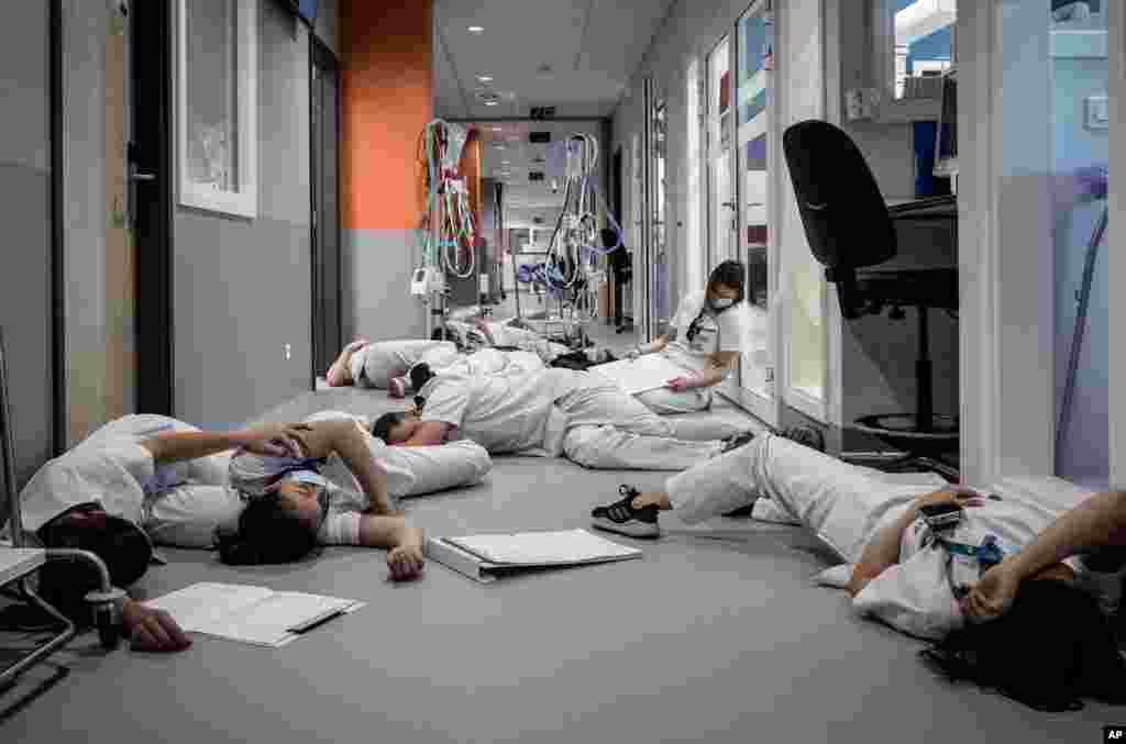 Nurses lay on the floor in the ICU unit during a demonstration on International Nursing and Care day, at the Mont Legia Hospital in Liege, Belgium.