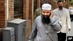 FILE - In this April 11, 2007 file photo, Egyptian cleric Osama Hassan Mustafa Nasr, also known as Abu Omar, who was allegedly kidnapped by CIA agents in an Italian city and taken to Egypt, talks on his mobile phone as he walks in a Cairo street.