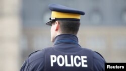 FILE - A Royal Canadian Mounted Police officer works on Parliament Hill in Ottawa, Ontario.