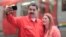 Venezuela's President Nicolas Maduro takes a selfie next to his wife, Cilia Flores, as they arrive for a rally with workers of transport sector in Caracas, Venezuela, Jan. 24, 2018.
