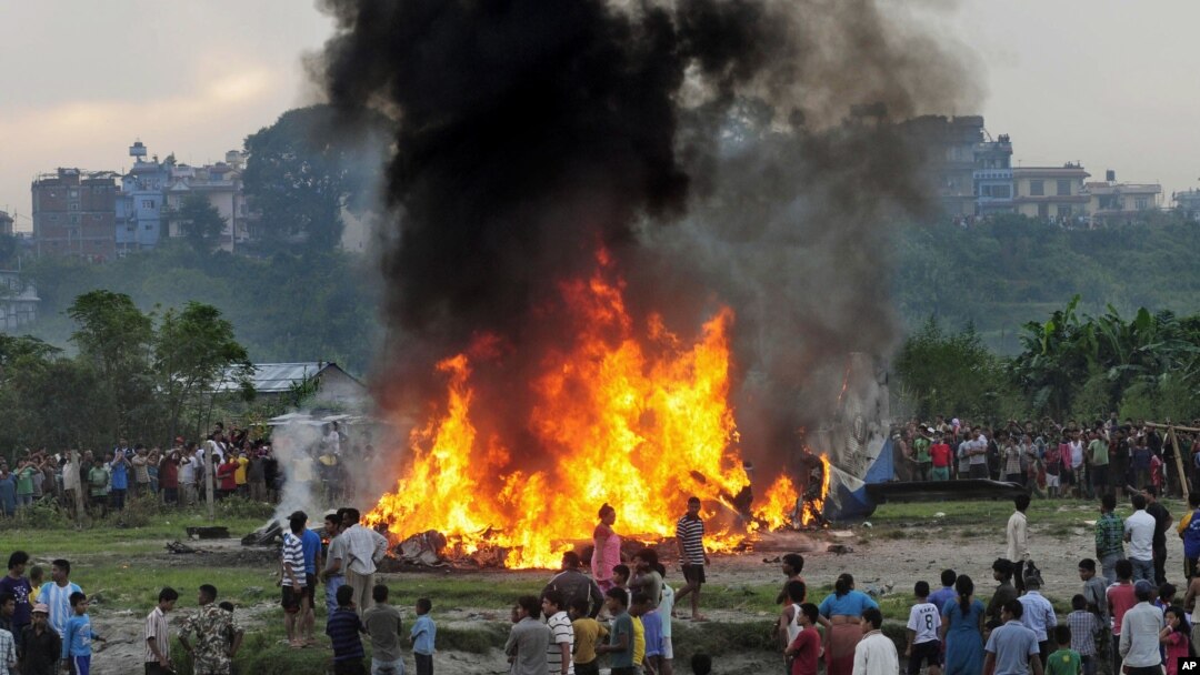 Warga Nepal berkerumun mengelilingi kepingan pesawat "SIta Air" yang terbakar dan jatuh dekat Katmandu, Nepal (28/9).