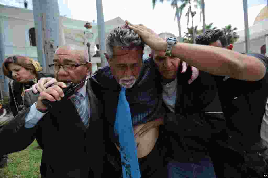 Opposition lawmaker Americo De Grazia is injured when government supporters force their way into the Venezuela&#39;s opposition-controlled National Assembly during a special session in Caracas.