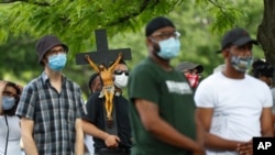 Un sacerdote carga un crucifijo durante una protesta en Detroit, Michigan, por la muerte de George Floyd, el pasado 25 de mayo.
