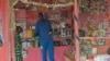 FILE - A shopkeeper hands an item to a girl in his shop in Juba, South Sudan, March 1, 2019.