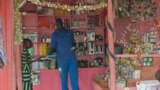 FILE - A shopkeeper hands an item to a girl in his shop in Juba, South Sudan, March 1, 2019.