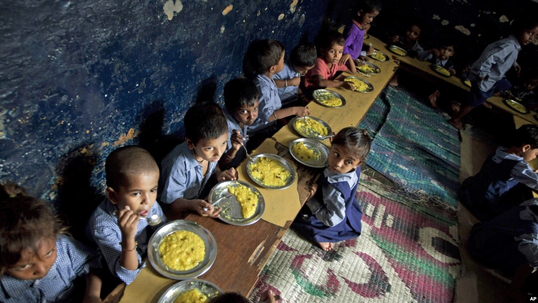 Children eat a meal at a school in a shanty neighborhood of New Delhi, India, Sept. 13, 2012.