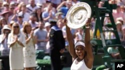 FILE - Serena Williams of the United States reacts as she holds up the trophy after winning the women's singles final against Garbine Muguruza of Spain, at the All England Lawn Tennis Championships in Wimbledon, London, July 11, 2015. 