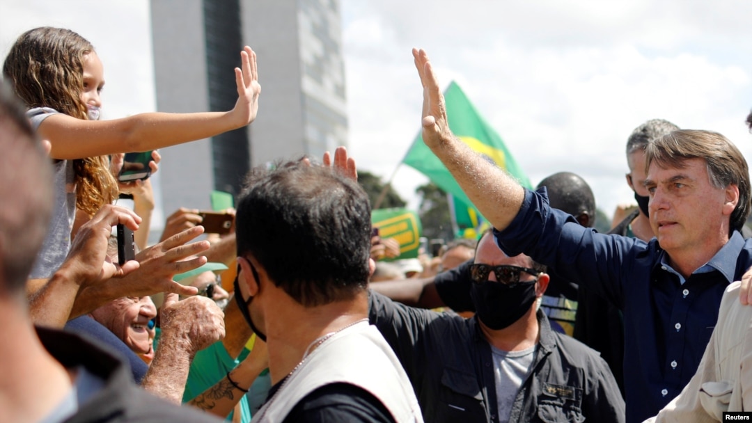 Presiden Brazil Jair Bolsonaro menyapa para pendukungnya di depan Istana Planalto di tengah pandemi virus corona (Covid-19), 24 Mei 2020. (Foto: Reuters)